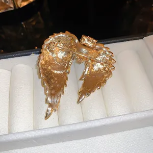High-quality detail shot showing the back pin mechanism of this gold angel wing brooch