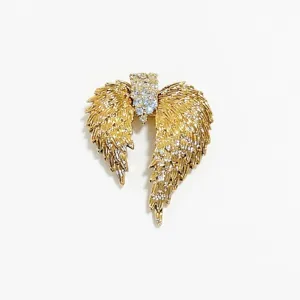 Elegant gold-toned angel wing brooch featuring sparkling rhinestone center on white background