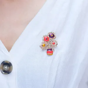 Detailed macro shot of a colorful floral enamel brooch pinned on white knitwear