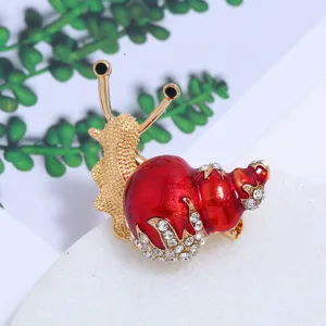 Detailopname van een luxe rode emaille slakkenbroche met fonkelende kristalaccenten