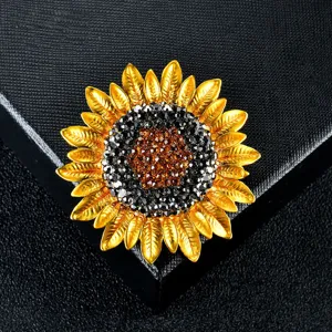 Macro view of a luxurious golden sunflower brooch encrusted with sparkling crystals.