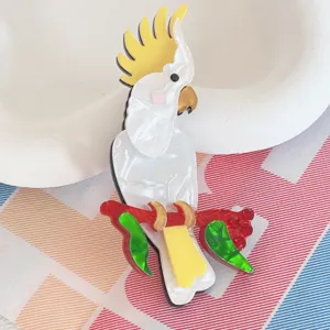 Macro detail of acrylic cockatoo brooch with pearlescent white and yellow finish