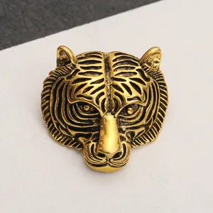 Detailed view of a vintage style golden tiger head brooch with intricate black details