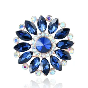 Detailed macro shot of an elegant sunflower crystal brooch with sparkling blue gems.