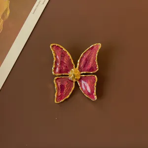 Close-up of a vintage baroque butterfly brooch featuring purple enamel and gold trim details