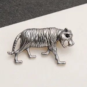 Detailed close-up of a vintage silver tiger brooch with intricate stripes and stone eyes
