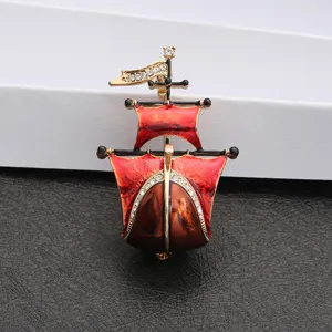 Close-up of vintage red enamel sailing ship brooch with crystal accents