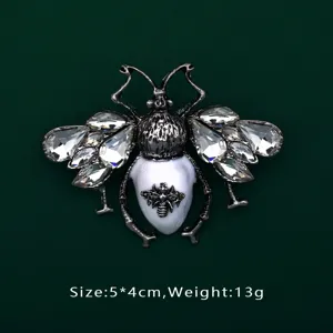 Detail shot of a vintage Baroque bee brooch with faceted crystals and white center
