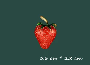 Nahaufnahme einer roten Erdbeer-Emaille-Brosche mit den Maßen 3,6 cm mal 2,8 cm