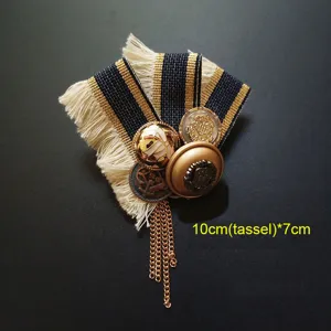 Primer plano de un broche barroco vintage con borlas doradas y cinta de rayas elegante