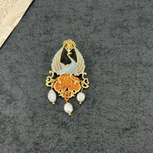 Detailed close-up of vintage enamel peacock brooch with three dangling baroque pearls