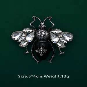 Detail view of a luxury crystal bee brooch with black enamel and vintage silver finish