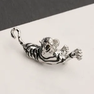 Detailed macro view of a vintage silver tiger brooch with black enamel stripes ornamentation.