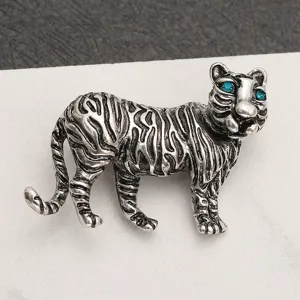 Detailed view of a vintage silver tiger brooch with sparkling blue rhinestone eyes.