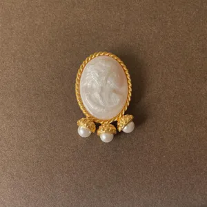 Detailed view of a vintage Baroque cameo brooch with pearl tassel drops
