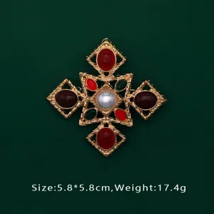 Detailed macro view of luxury red baroque brooch featuring pearl and green gemstones