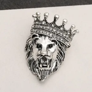 Detailed view of a retro lion head brooch with crown and sparkling rhinestones