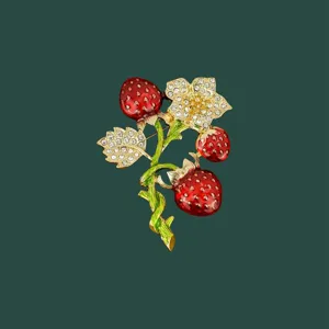 Detaillierte Nahaufnahme einer Vintage-Emaille-Brosche mit Erdbeeren und Kristallen