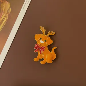 Close-up of vintage golden enamel dog brooch with reindeer antlers and red bow tie