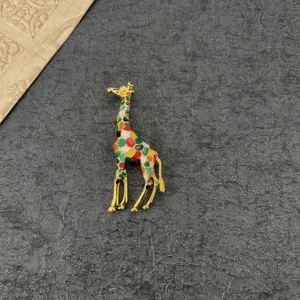 Close-up of a vintage giraffe brooch with colorful enamel on a textured background