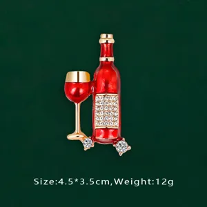Close-up detail of red enamel wine bottle and glass brooch with crystal accents