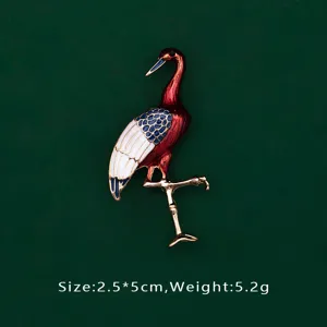 Close-up of elegant red and white enamel crane brooch with gold-tone finish