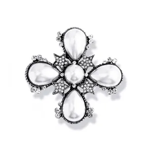 Detailed shot of a vintage Baroque cross brooch with pearls and sparkling rhinestones