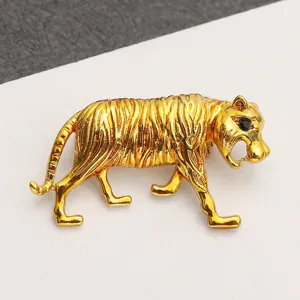 Detailed view of a vintage gold-toned alloy tiger brooch with intricate textured stripes.