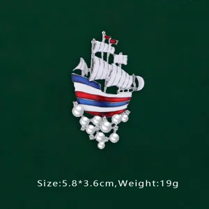 Detailed view of nautical sailing ship brooch with pearls and enamel hull