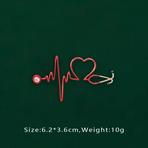 Close-up detail of a red stethoscope brooch with heart pulse shape and crystal