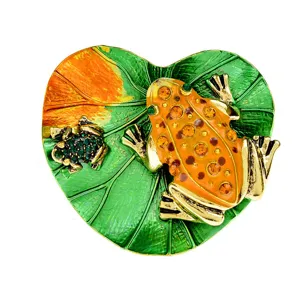 Detailed view of vivid frog and leaf brooch with sparkling rhinestone embellishments
