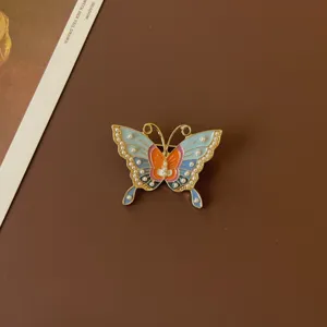 Detailed view of a vintage butterfly enamel brooch with colorful wings and pearls