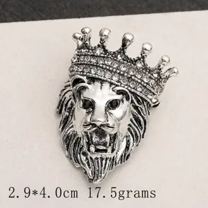 Macro detail showing a retro silver lion head brooch with a crown and rhinestones