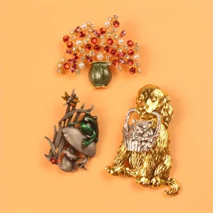 Detailed view of three unique animal and floral brooches with crystals and pearls