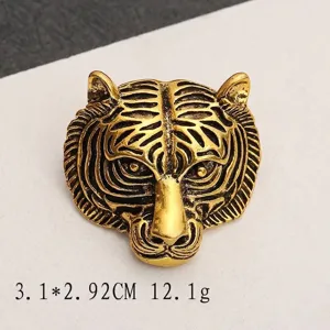Detailed close-up view of a vintage tiger head brooch with antique gold finish texture