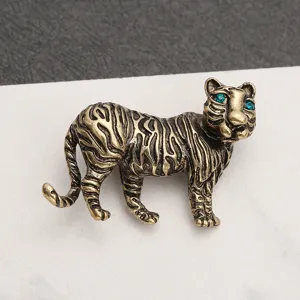 Detailed view of an antique bronze tiger brooch with turquoise rhinestone eyes