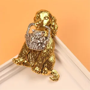 Detailed view of a gold-toned dog brooch holding a silver-toned cat in a basket.