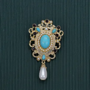 Macro view of a vintage Baroque brooch with turquoise and pearls on green background