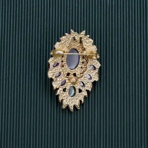 Detailed back view of a vintage Baroque style gold-tone brooch showing the pin closure