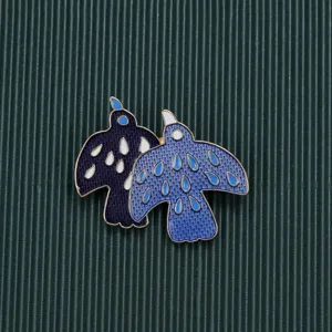 Detailed macro view of vintage baroque style double bird enamel brooch with blue patterns