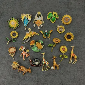 Collection of vintage enamel brooches featuring sunflowers, animals, and floral designs