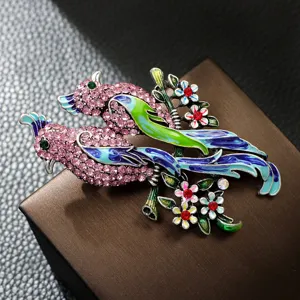 Detalle de un elegante broche de pájaro en esmalte con pedrería rosa y toques azules