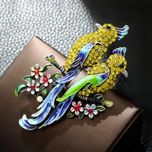 Primer plano de elegante broche de ave en esmalte con cristales amarillos
