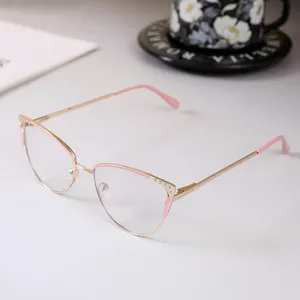 Vista detallada de monturas de gafas de ojo de gato en metal con strass y toques rosa.