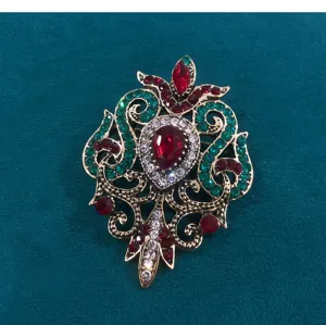 Detaillierte Makroansicht einer Vintage-Brosche im Barockstil mit roten Kristallen