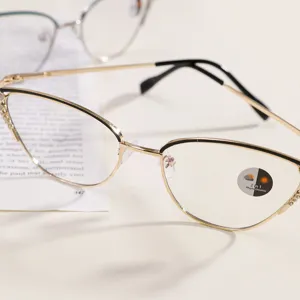 Detalle de montura de gafas cat-eye doradas con brillantes y lente fotocromática.