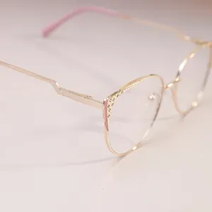 Vista detallada de gafas de gato doradas con detalles de pedrería y puntas rosas