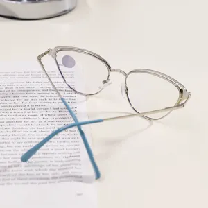 Vista detallada de montura de gafas ojo de gato en metal plateado con puntas azules.