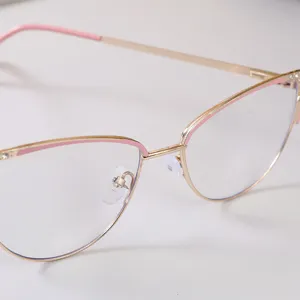 Primer plano de montura de gafas ojo de gato de metal dorado con detalles rosas