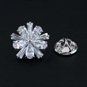 Elegante broche de copo de nieve con circonitas cúbicas sobre fondo de cuero negro.